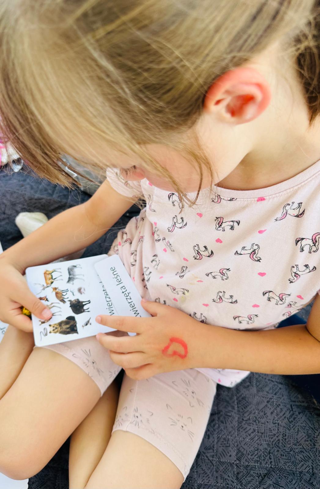 Dziewczynka pracująca z kartami edukacyjnymi